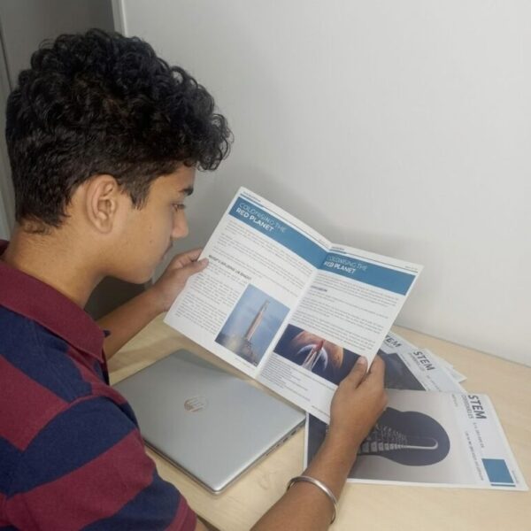 Student reading a feature article in STEM Chronicles magazine